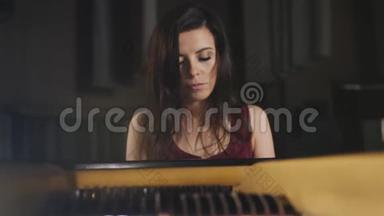 那个女人在音乐厅里弹钢琴，靠近一个女人。